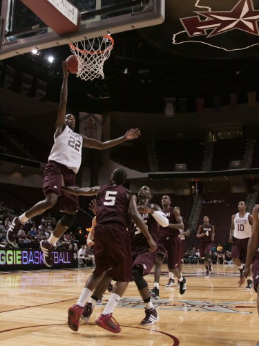 A&M's forward Khris Middleton leaps over guard Dash Harris to lay in a basket.