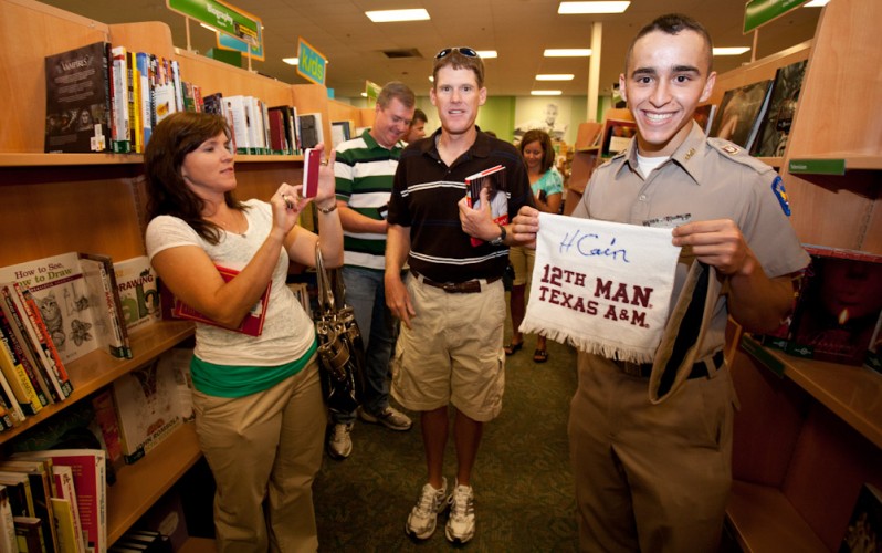 An A&M Corps freshman shows off the 12th man towel he got signed by Herman Cain
