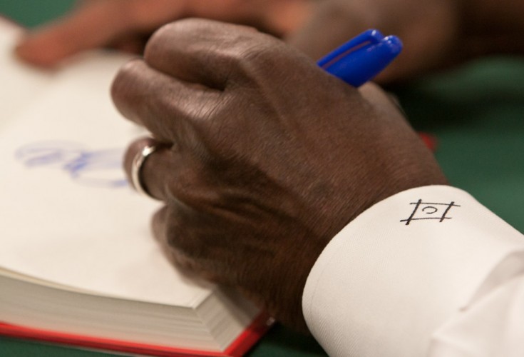 A close-up of Herman Cain's hand as he signs a copy of his book.