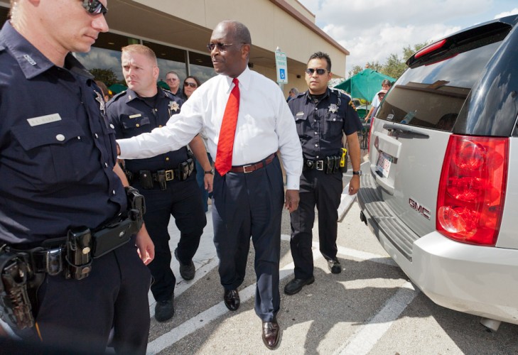 Herman Cain leaves his book signing in College Station, TX surrounded by 3 police officers.